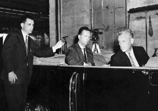 A photograph of Warren Commission’s Arlen Specter taken at garage, following reenactment of assassination on May 24, 1964, depicting probable angle of bullet which passed through President Kennedy and Governor Connally. (Photo -Warren Commission)