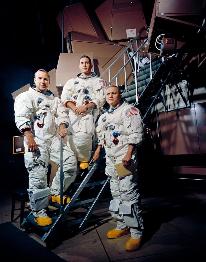 crew of the Apollo 8 lunar orbit mission. Left to right, are James A. Lovell Jr., command module pilot; William A. Anders, lunar module pilot; and Frank Borman, commander. They are standing beside the Apollo Mission Simulator at the Kennedy Space Center (KSC)