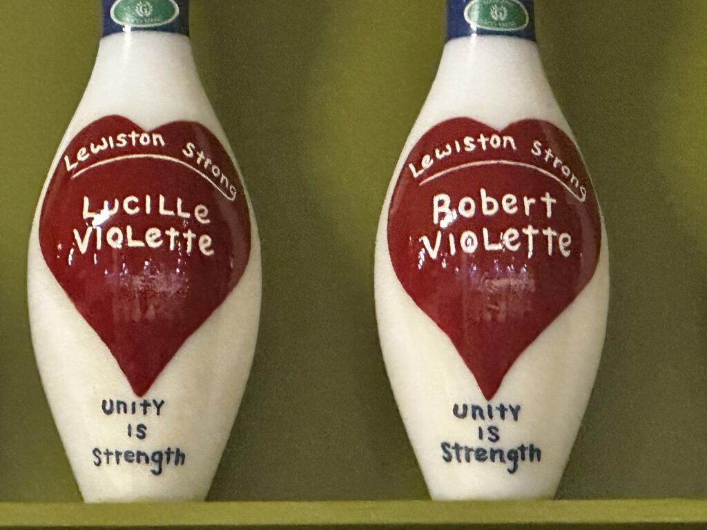 Bowling pins painted with names of two victims of the tragic shooting at the recently reopenedJust - In - Time Recreation center in Lewiston, Maine