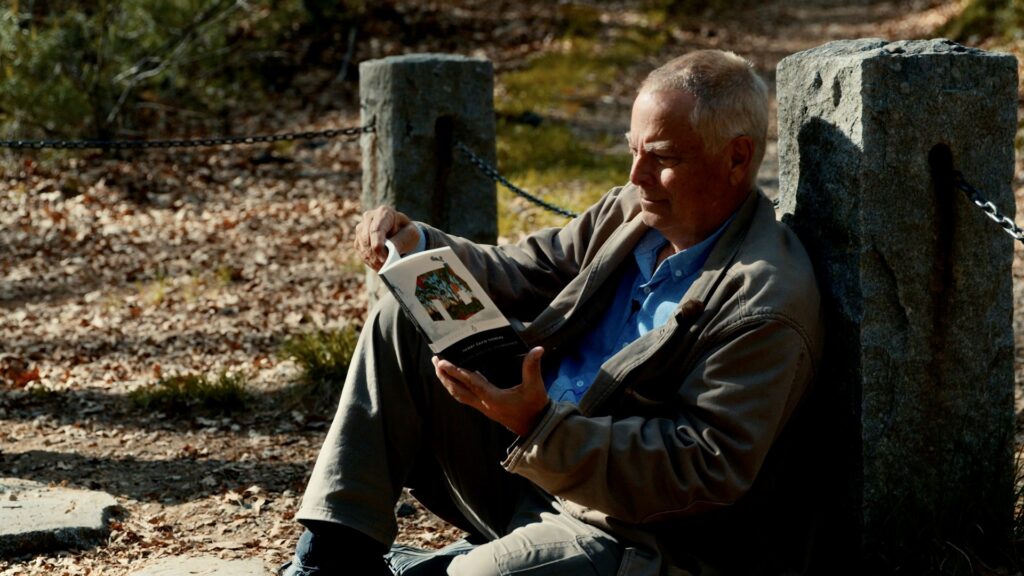 Clay reads from his "bible" at the former site of Thoreau's famous cabin at Walden Pond outside of Concord, Massachusetts. (Photo Nolan Johnson)