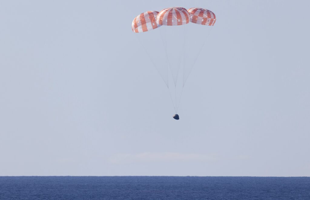 NASA’s Orion spacecraft under parachutes as it lands in the Pacific Ocean off the coast of California, Friday, April 10, 2026.