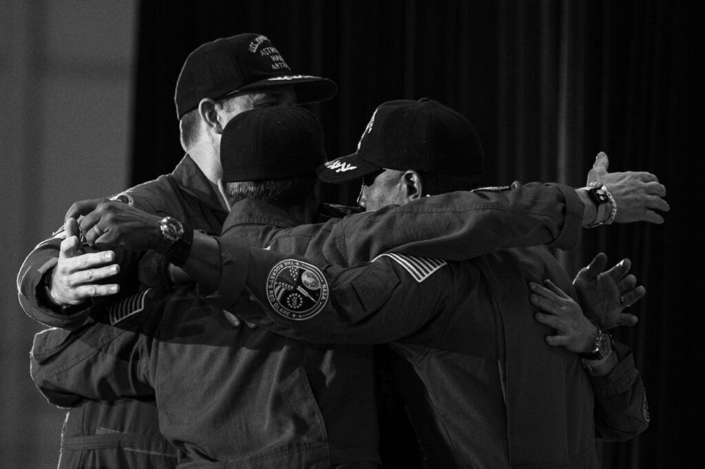 The Artemis II crew embrace during a return event, Saturday, Apr. 11, 2026, at Ellington Field in Houston.