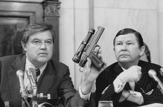 Senator Frank Church holds CIA poison dart gun at a committee hearing with Vice Chairman John Tower on September 17, 1975.